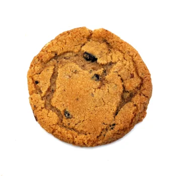 Cookie doré au caramel avec des morceaux visibles de caramel et de chocolat, affichant une texture croquante sur les bords et moelleuse à l'intérieur.